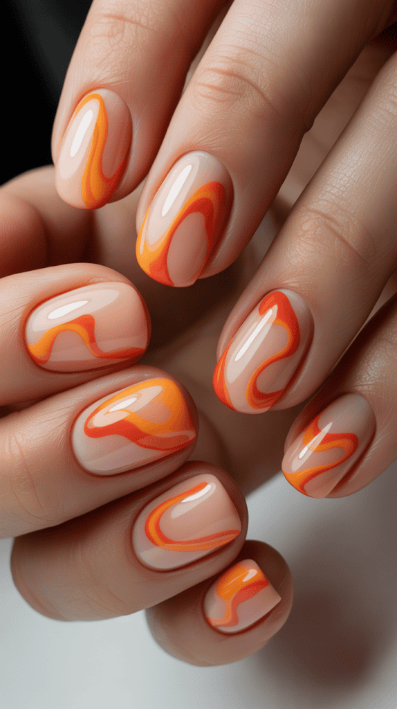 Close-up of vibrant orange and yellow swirl nail art for summer.